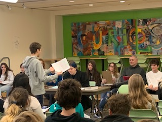 student stands in front of group to give a speech