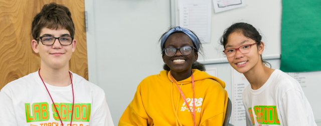 Three students sitting together in a classroom