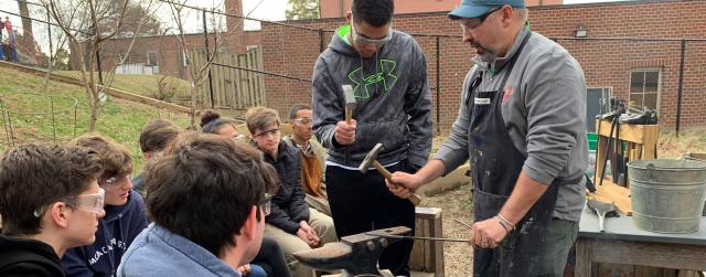 student and teacher using metalsmithing tools